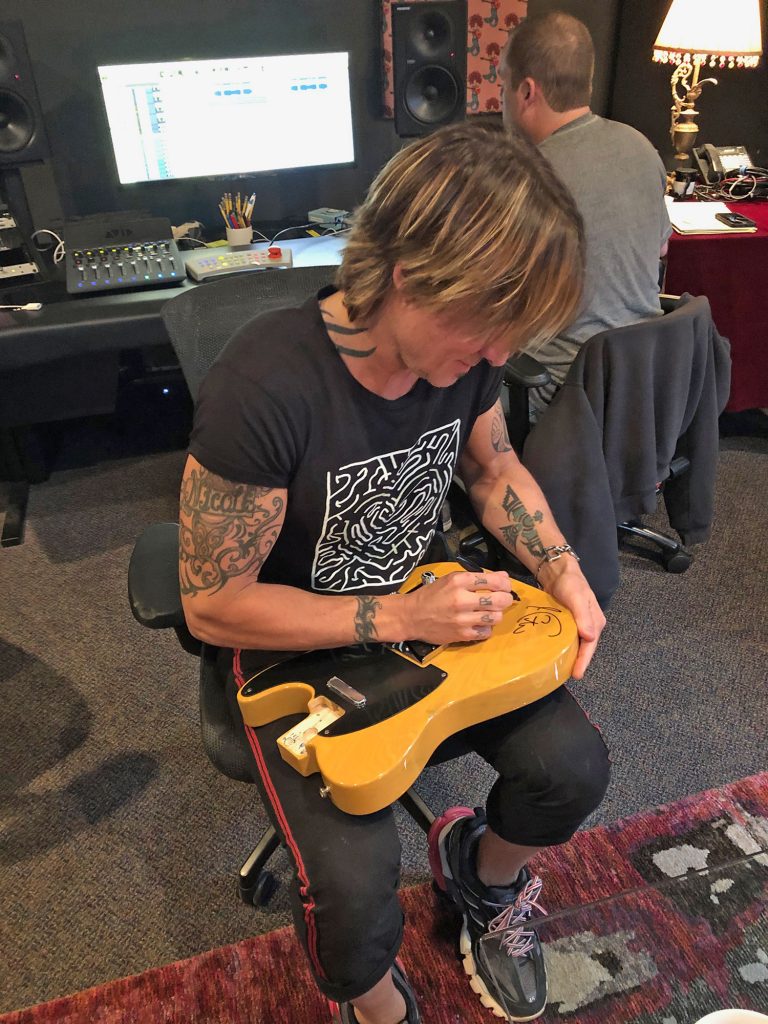 keith Urban signing a guitar